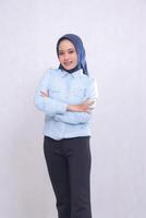 young indonesia office woman wearing a blue shirt hijab standing smiling cheerfully with arms crossed. Beautiful Muslim women use business, finance and fashion content photo