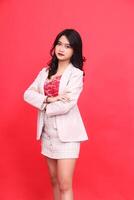 Portrait of an elegant young Asian Indonesian woman on the left side wearing a cream-colored blazer. Isolated red background for content materials, banners, advertising. photo