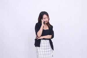 the charm of a beautiful Asian office woman in her 20s, expression chatting on a cellphone gadget with her arms crossed, isolated on a white background photo