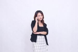 the charm of a beautiful Asian office woman in her 20s with a sullen expression while making a phone call on a cellphone gadget with her arms crossed isolated on a white background photo