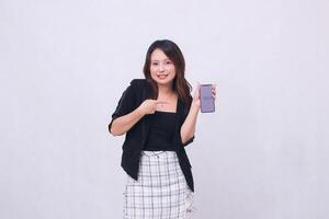 beautiful Indonesian office girl 20s smile expression promotion cellphone gadget screen for promo while pointing at it underneath isolated white background photo