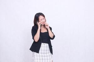 the charm of a beautiful Asian office woman in her 20s with a bitter expression while making a phone call on a cell phone while holding her hand to her mouth isolated on a white background photo
