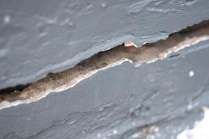 Large cracks in the gray cement wall, Close up view photo