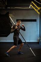 Boxer practicing punches with barbell for explosive strength at gym photo