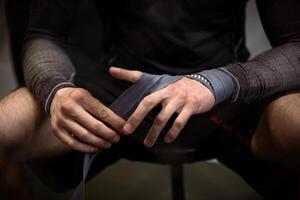 Boxer wrapping hands with boxing handwraps before training photo