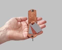 Bespoke brown leather key holder with printed family portrait in male hand photo