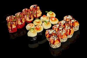 Baked uramaki and norimaki sushi rolls with cheese and sauces photo
