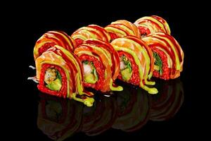 Red rice sushi rolls with tempura shrimp and salmon on black photo