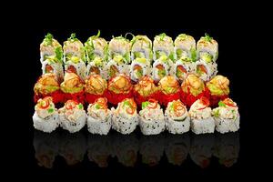 Enticing set of sushi rolls with various fillings and toppings on black photo