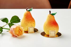 Exquisite pear-shaped pastries with delicate rose on white photo