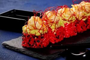 Red sushi rolls with avocado, shrimp and togarashi threads photo