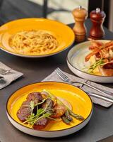 Plate with steak, baked potato and asparagus on table set for dinner photo
