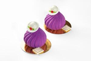 Velvety purple mousse desserts in shape of swirls with chocolate hats photo