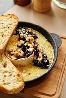 Torched Camembert with currant jam, hazelnuts and toasts photo
