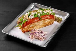 Sandwich in toasted brioche bread with chicken fingers, vegetables, mayo and cashews photo