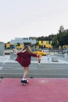 Teen girl skater with a skateboard is sitting and resting in the skaters park photo