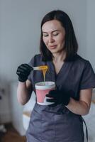 Depilation master shows shugaring depilation spatulas in his hands photo