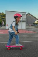 Cute little girl stands with a skateboard photo