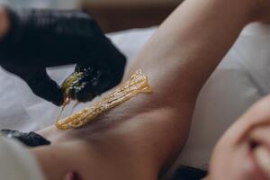 Sugaring. epilation with liquate sugar at armpit. photo