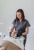 cosmetologist and client in a beauty salon doing procedures. Using a face mask photo
