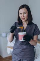 Depilation master shows shugaring depilation spatulas in his hands photo