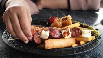 Capture the food platter up close, showing sausages, cheese, and fries a spread for any occasion video