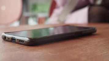 man hand picking up smart phone mobile to receive a call video