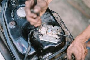A motorcycle mechanic inspecting a damaged engine photo