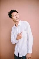 A man pointing to the right, indicating a direction or drawing attention to something off-camera with a confident gesture photo