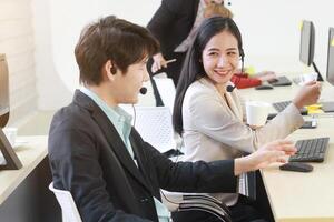 Business Call Center and technical Support staff or receptionist phone operator Discussing and working for teamwork with computer. Asian customer support team. photo