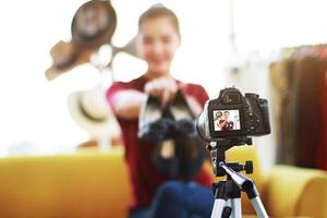 Beautiful Asian woman blogger recording on Dslr Camera for selling shoes online shopping on website. Marketing in social media concept. Close up and focus on Dslr Camera. photo