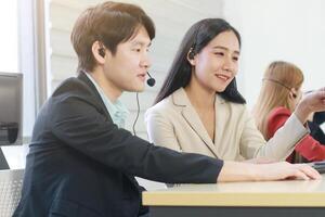 Business Call Center and technical Support staff or receptionist phone operator Discussing and working for teamwork with computer. Asian customer support team. photo