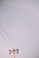 A lone utility pole against a clear sky, offering ample space for text or graphics, perfect for conveying messages or advertisements photo