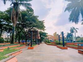 A picturesque pedestrian zone in TMII, inviting strollers to explore Indonesia's diverse culture amidst lush greenery and vibrant architecture. photo