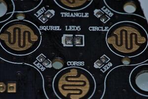 a close up of a circuit board with gold and silver circles photo