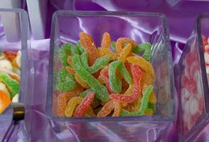 a display of different colored gummy worms photo