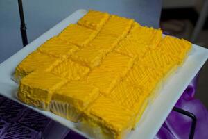 a square of yellow cake on a plate photo