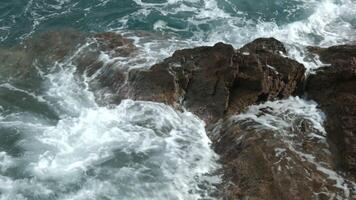 Beautiful view of the sea beating against the rocks.Creative.Beautiful large mountains on which there are houses located next to the undulating sea video