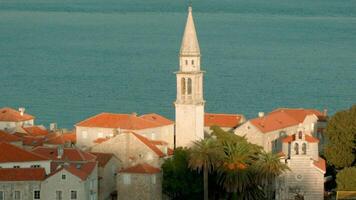 Timelapse effect of an old town with church and tower with sea ripples background. Creative. Beautiful nature and architecture. video