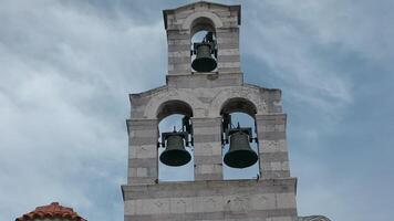 Large monuments standing next to the sea.Creative.A large stone tower and bell tower standing next to the sea with a small sail. video