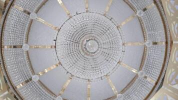 Bottom view of dome with crystal chandelier. Scene. Beautiful bright dome inside temple. Domed vault with crystal chandelier at top video