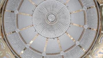 A huge glass chandelier.Scene.A white building with a painted ceiling on which hangs a huge fashionable chandelier made of small neat glass. video