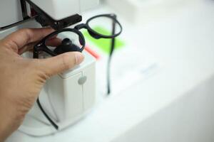 Hand holding eyeglasses in optical store photo