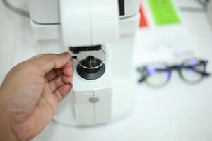 Hand holding eyeglasses in optical store photo