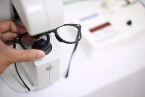 Hand holding eyeglasses in optical store photo