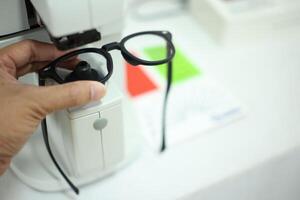 Hand holding eyeglasses in optical store photo