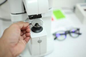 Hand holding eyeglasses in optical store photo