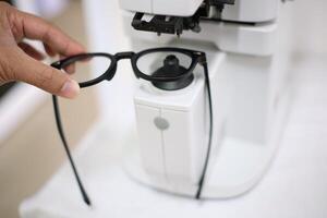 Hand holding eyeglasses in optical store photo