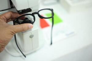Hand holding eyeglasses in optical store photo