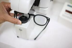 Hand holding eyeglasses in optical store photo